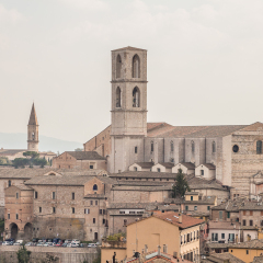 cityscape. aerial view of old houses and the Basilica di San Domenico against a blue sky background in old town of Perugia, Umbria, Italy