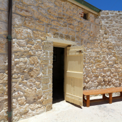 An old courtyard with a bench and door.