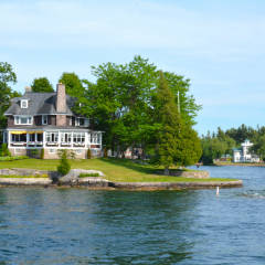 Island with house, cottage or villa in Thousand Islands Region in sunny summer day in Kingston, Ontario, Canada. 1000 Islands near Gananoque, ON. Famous Canadian tourist vacation routs.