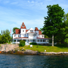 Island with house, cottage or villa in Thousand Islands Region in sunny summer day in Kingston, Ontario, Canada. 1000 Islands near Gananoque, ON. Famous Canadian tourist vacation routs.