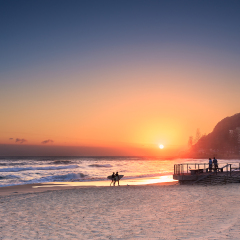couple surfers walks along the beach in Burleigh Heads (Gold Coast, QLD, Australia)