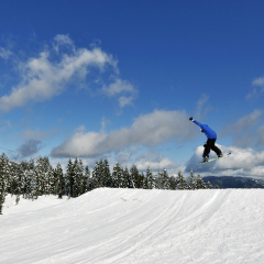 Snowboarder jumping high in the air on Mount Seymour