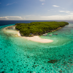 Aerial vertical panorama of Sumilon Island off of Cebu, Philippines featuring the shallow ocean floor and tourist landing area onto white sandy beach