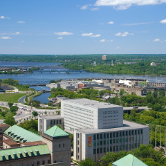 Aerial view looking west from downtown Ottawa.  National Archives in foreground.  Canadian War Museum in background.  View across ottawa river to Gatineau Quebec.