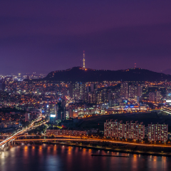 The lights of Seoul lit up at night, with Namsan Tower aglow in the distance.