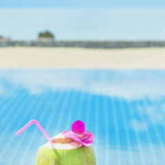 Summer, Travel, Vacation and Holiday concept - Tropical fresh coconut cocktail with pool and beach in ocean, Phuket ,Thailand
