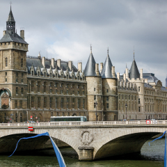 The imposing Conciergerie, a historical French monument, on Ile de la Cite , Quai de l'Horloge, Paris, France. The Pont de Change connects the Right Bank with  Ile de la Cite