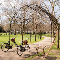 couple bicycles parking in front of arched entrance through the walk way in Russell square on weekend holiday leisure. romantic and fall in love with greenery color.