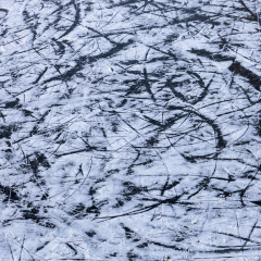 Background of ice surface with skates scratches in open rink