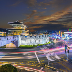 traffic blurs past Janganmun Gate at Hwaseong Fortress in Suwon, South Korea.
