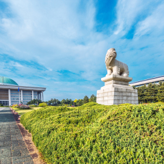 beautiful garden with stone statue in front of national assembly of south korea in cloud sky