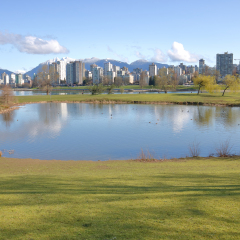 A large pond in Vanier Park with the city of Vancouver, Canada in the background/Pond in Vancouver's Vanier Park/A large pond with the city of Vancouver, Canada in the background. 