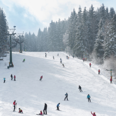 Ski resort winter season mountain slope with people sport skiing and snowboarding day time sunny weather