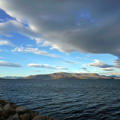 Cruise vessel on Faxa Bay leaving Reykjavik, Iceland, with Esja volcanic mountain range as backdrop. The cloud formation gives nice dynamism to the picture.