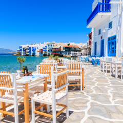 Chairs with tables in typical Greek tavern in Little Venice part of Mykonos town, Mykonos island, Greece