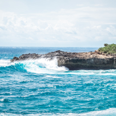 A beautiful blue wave crashes down at the rocks in Devil's Tear, tropical island Nusa Lembongan, Indonesia, Asia. Sunny day, big waves.