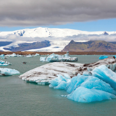 Icebergs in Jokulsarlon lagoon, part of the Vatnajokull glacier national park. in the background the sunlit Hvannaldshnúkur, Iceland's highest peak.