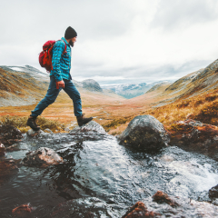 Man solo traveling backpacker hiking in scandinavian mountains active healthy lifestyle adventure journey vacations