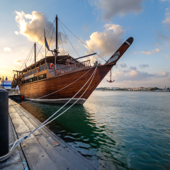 DUBAI, UAE - DECEMBER 2 2014: Traditional wooden dhow cruise across the Creek with a view of skyline of Dubai, United Arab Emirates