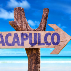 Acapulco wooden sign with beach background