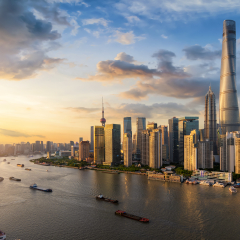 View over the Huangpu river to the modern skyline of Shanghai, China, during sunset time