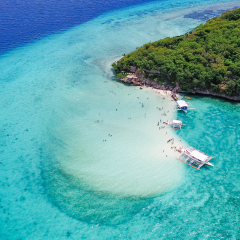 Aerial view of sandy beach with tourists swimming in beautiful clear sea water of the Sumilon island beach landing near Oslob, Cebu, Philippines. - Boost up color Processing.