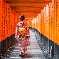 KYOTO, JAPAN - 2016 September 9: Women in kimono walking at Red Torii gates in Fushimi Inari shrine, one of famous landmarks in Kyoto, Japan
