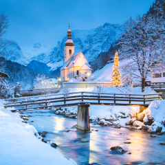 Beautiful twilight view of Sankt Sebastian pilgrimage church with decorated Christmas tree illuminated during blue hour at dusk in winter, Ramsau, Nationalpark Berchtesgadener Land, Bavaria, Germany
