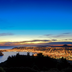 Hill top view of Dunedin City. From the top, one can enjoy beautiful city lights, sunset and colorful sky. Dunedin is a popular tourist destination in South Island of New Zealand.