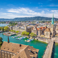 Aerial view of historic Zurich city center with famous Fraumunster Church and river Limmat at Lake Zurich from Grossmunster Church on a sunny day with clouds in summer, Canton of Zurich, Switzerland