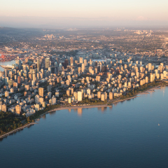 Aerial view of Stanley Park and Downtown Vancouver, BC, Canada. During a hazy sunny sunset.
