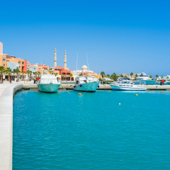 The bright blue waters of the Red sea surrounded by the modern colorful buildings of Marina, Hurghada, Egypt.