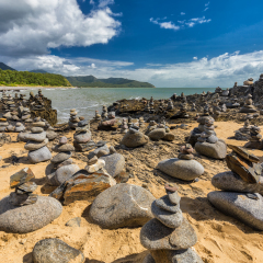 Stacked balancing rocks on the beach between Cairns and Port Douglas, Queensland, Australia