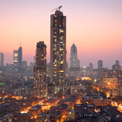 Panoramic view of south central Mumbai - the financial capital of India - at golden hour with dwellings of lower middle class in foreground and towers where elite stay in the far background. 