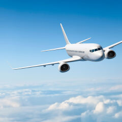 White passenger aircraft flying over clouds
