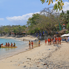 BALI, INDONESIA - SEPTEMBER 13, 2015: Tourists on Mushroom Beach at Nusa Lembongan Island, Bali on Sep 13, 2015. This island is located on Southeast of Bali and popular destination to dive and surf.
