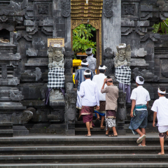 Asia, Indonesia, Bali. 19 March 2014. Men and boys enter the main gate of the Hindu temple: Pura Goa Lawah Temple of the Bat Caves.
