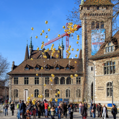 Zurich, Switzerland - 29 January, 2017: a group of people launching balloons bearing the symbolic of the C3 Church on the square at the entrance to the Swiss National Museum.