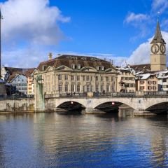 Zurich, Switzerland - 1 February, 2015: the Munsterbrucke bridge over the Limmat river, clock towers of the Fraumunster and Saint Peter church. Zurich is the largest city in Switzerland.