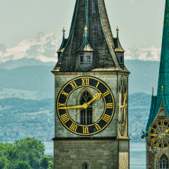 Saint Peter and FraumÃ¼nster Church in Zurich (Switzerland) in front of lake Zurich and the Swiss Alps, HDR-technique