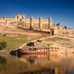 Amber Fort illuminated by warm light of the rising sun and reflected in the lake. Famous Rajasthan landmark located nearby Jaipur city in north-western India.