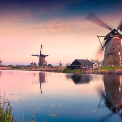 Colorful spring scene in the famous Kinderdijk canals with windmills, UNESCO world heritage site. Sunset in Dutch village Kinderdijk, Netherlands, Europe.