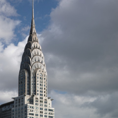 Top of Chrysler building with white and dark clouds behind it - May 3, 2017, 40th Street, New York City, NY, USA