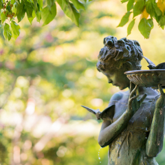 New York City, USA - September 24, 2016. Sculpture of a girl with a bird bath at the Burnett Memorial fountain. Natural setting with a bronze fountain statue in Conservatory Garden, Central Park.