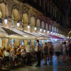 BARCELONA, SPAIN - JULY 18, 2016: Famous Placa Reial (Royal Square) with restaurants and other facilities illuminated at night in Barcelona