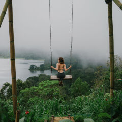 Woman on the swing over the jungles and lake  in Bali
