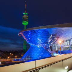 MUNICH, GERMANY - MARCH 17, 2015: BMW World (BMW Welt) with Olympic Tower illuminated in green on St. Patrick's Day. 