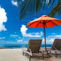 Beautiful beach background for summer travel with sun,coconut tree and beach wooden bed on sand with beautiful blue sea and blue sky. Summer mood sun beach background concept.
