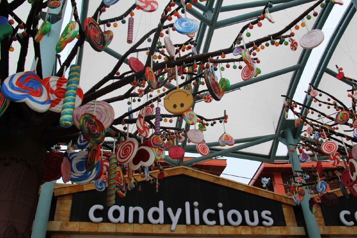 门口有几个巨大的mm豆,店铺顶上挂满了糖果,超级美好,大家争先合影~一