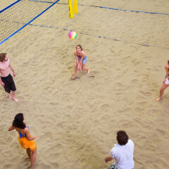 Aerial view of friends playing indoor beach volleyball